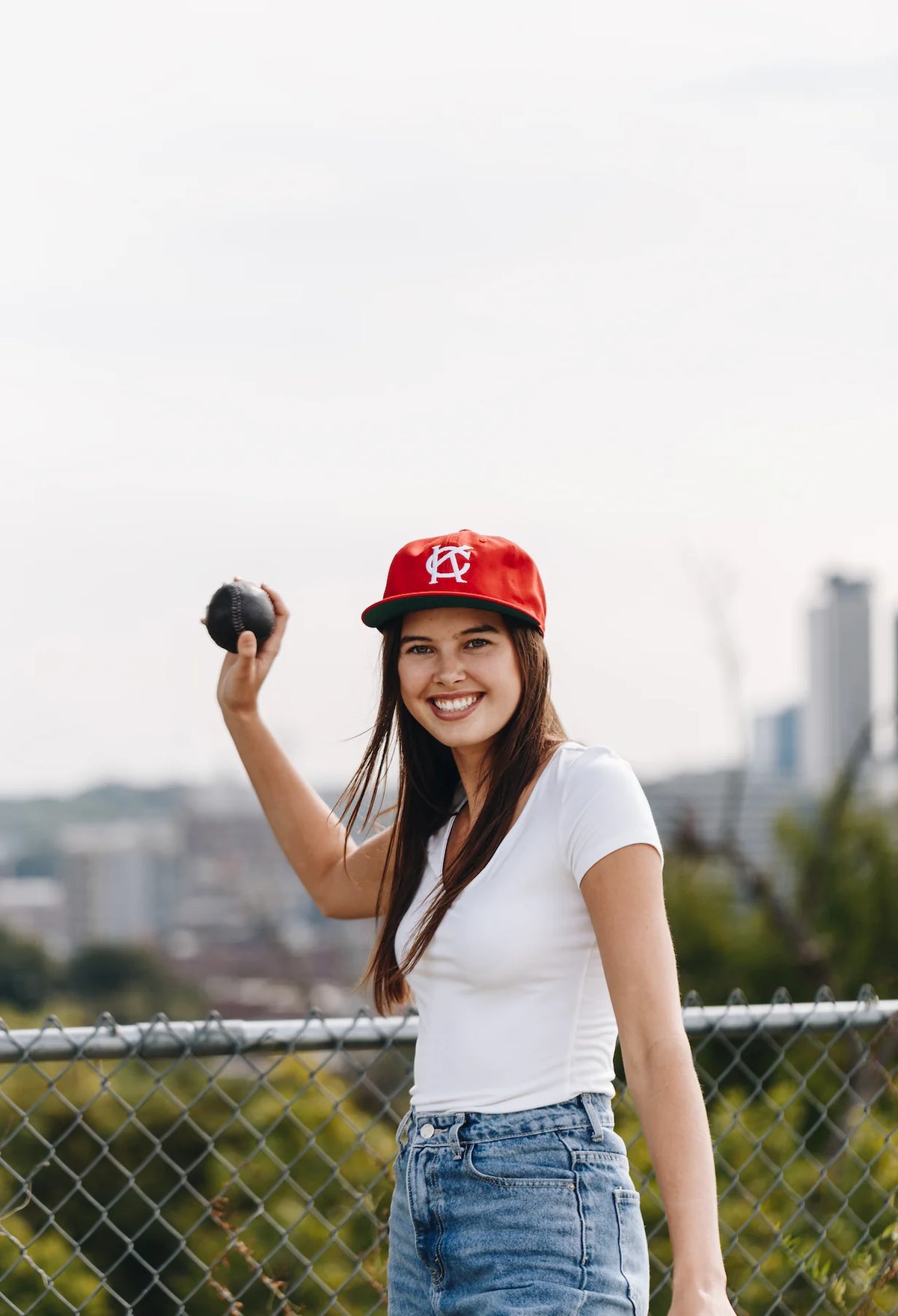 Woman ready to throw the Black Yardball outdoors - handmade leather ball for catching and tossing bare-handed