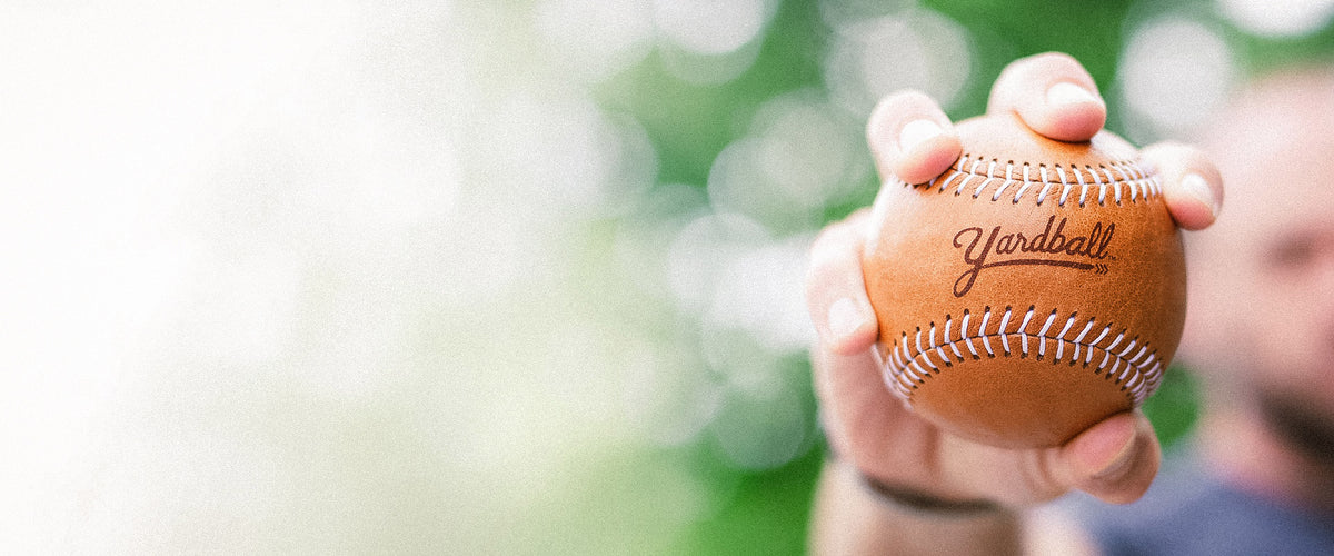 Hand squeezing a Glove Tan Yardball outdoors
