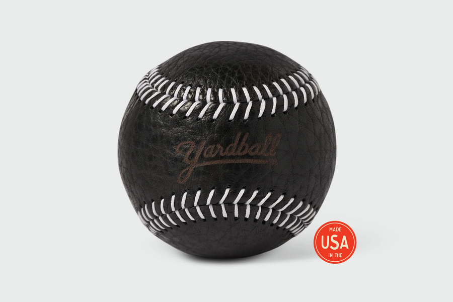 Black Yardball close-up showing white stitching detail and Yardball script on premium black leather